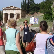 image of tourist guide with visitors at Delphi archaeological site, Greece
